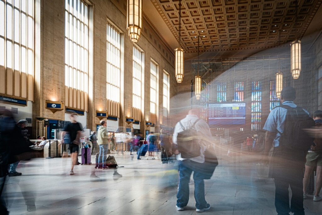 Travelers with luggage walk through the Amtrak station in Philadelphia.