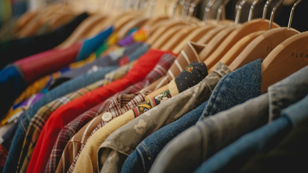 Close-up photo of shirts on a rack. Shirts are different colors.